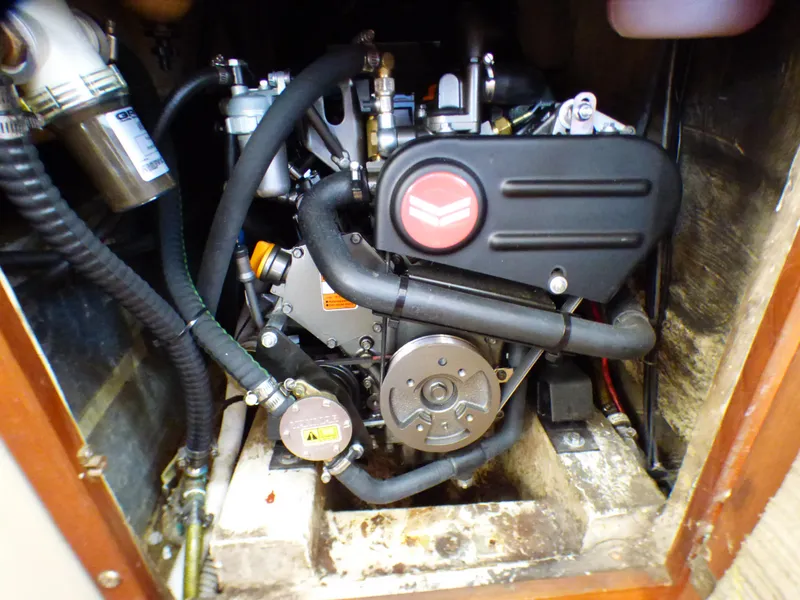 Engine compartment of a 1982 Catalina 38 sailboat, showcasing mechanical components and hoses.