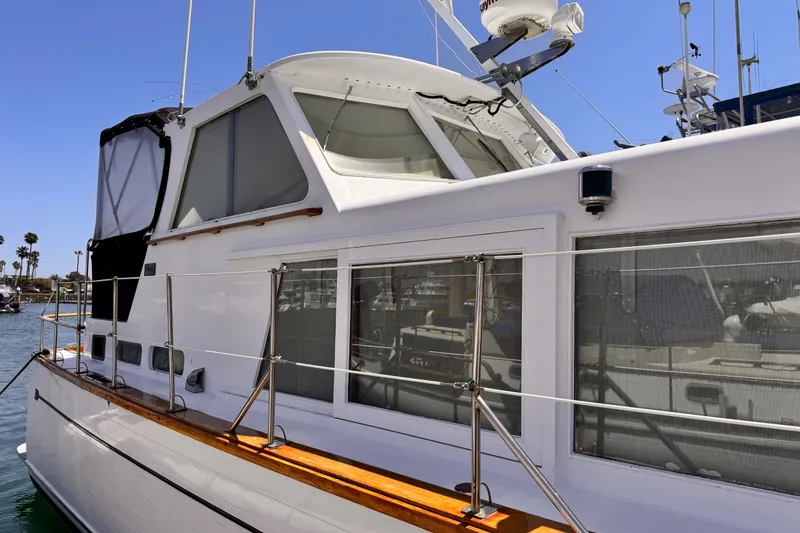 1978 Roughwater 41 boat docked, featuring sleek design and spacious cabin windows.
