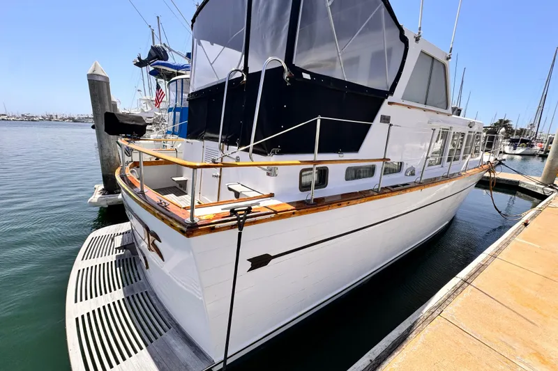1978 Roughwater 41 boat docked at marina under clear blue sky.