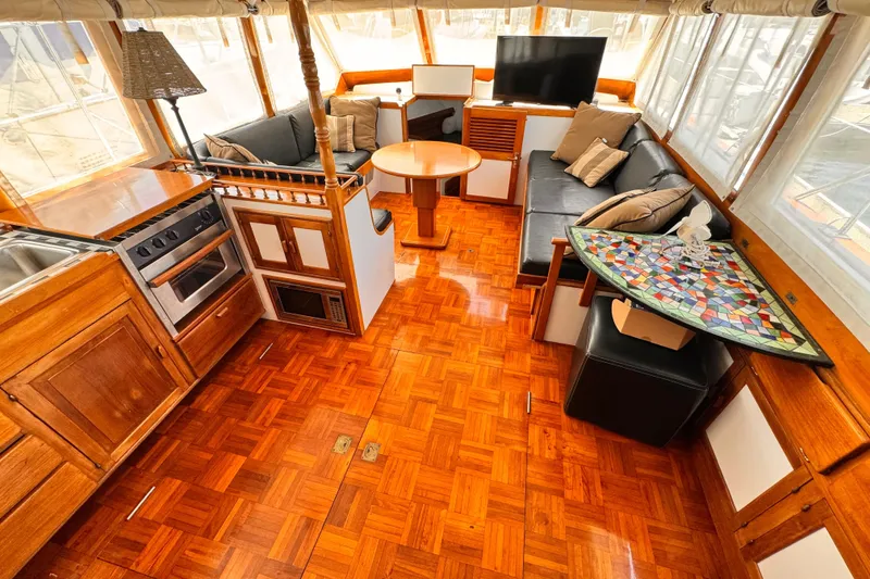 1978 Roughwater 41 yacht interior with wood flooring, kitchen, seating area, and TV.