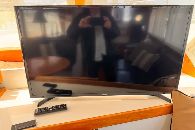 Samsung TV with remote on a 1978 Roughwater 41 boat interior.