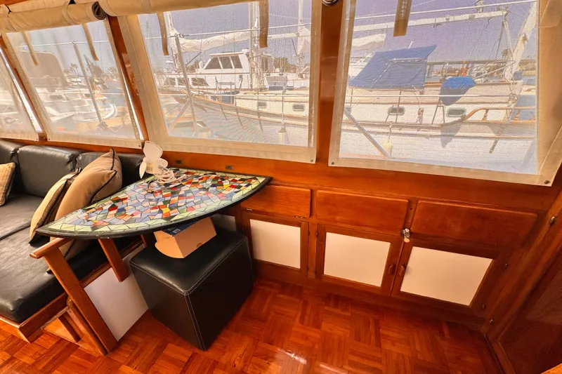 Interior of 1978 Roughwater 41 boat with mosaic table and leather seating.