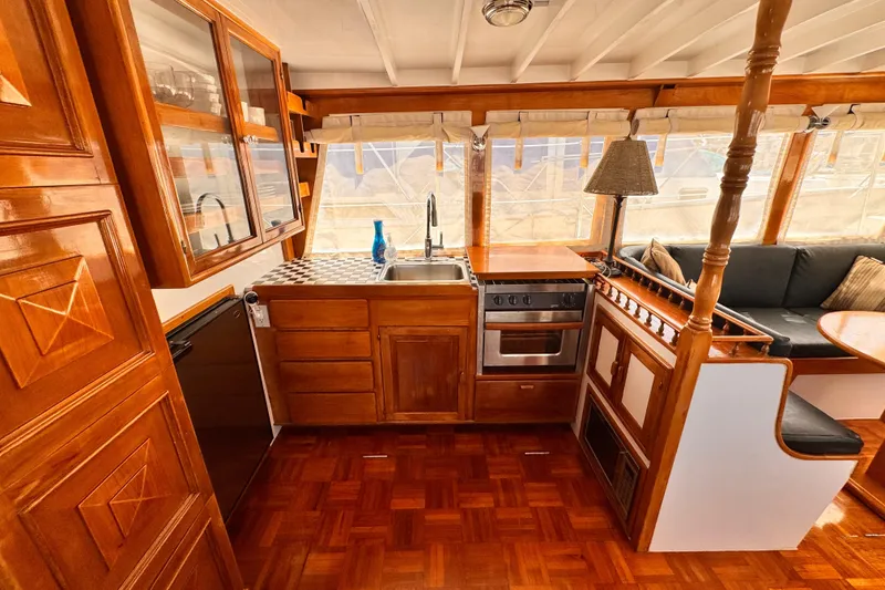 1978 Roughwater 41 boat interior with wooden cabinetry, kitchen, and seating area.