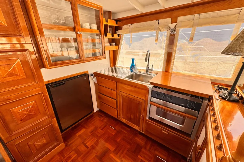 1978 Roughwater 41 yacht kitchen with wooden cabinetry, stainless steel sink, and modern appliances.