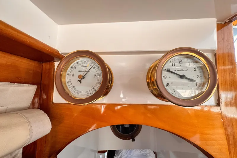 Vintage Roughwater 41 yacht interior with barometer and clock, showcasing classic wooden design.