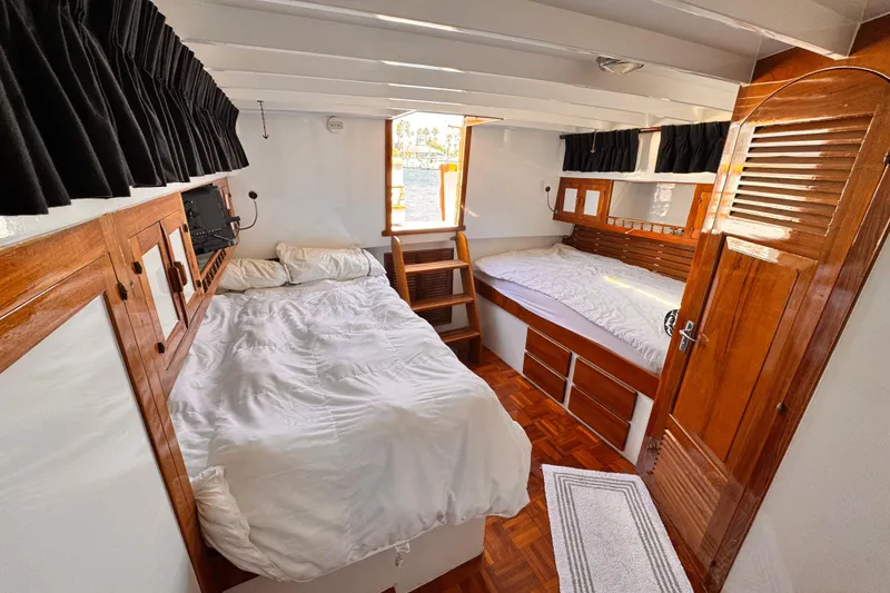 Cozy cabin interior of 1978 Roughwater 41 boat with wooden accents and twin beds.