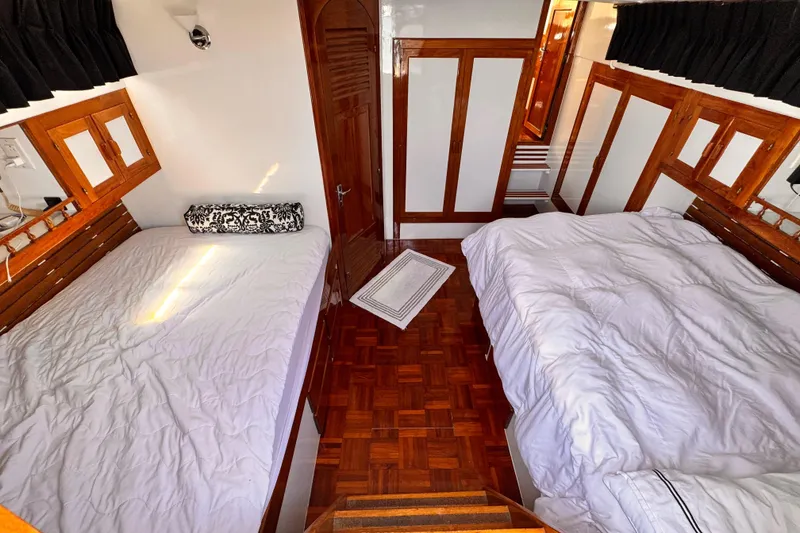 Interior of 1978 Roughwater 41 boat with twin beds and wooden accents.