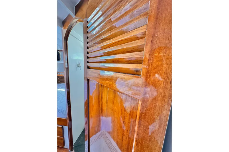 Polished wooden interior door of a 1978 Roughwater 41 boat cabin.