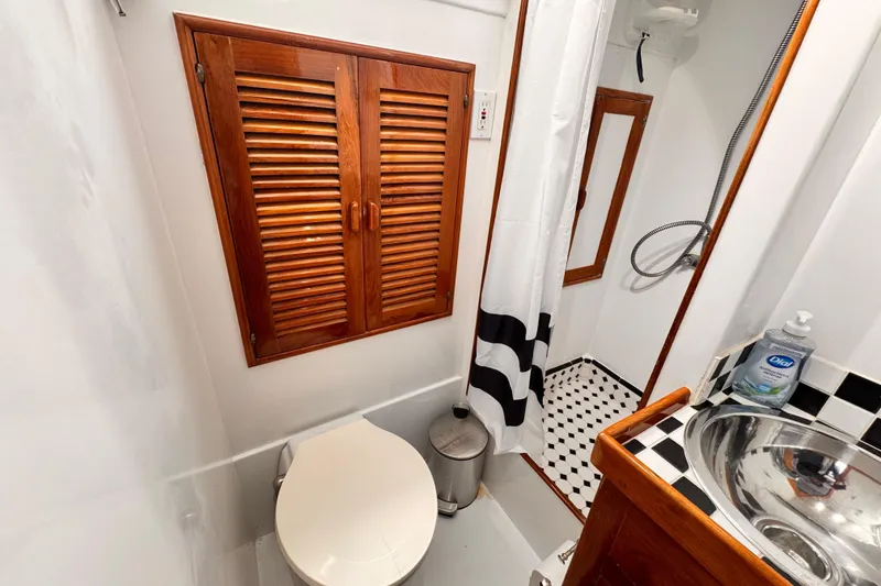 Bathroom interior of 1978 Roughwater 41 boat with wooden accents and modern fixtures.