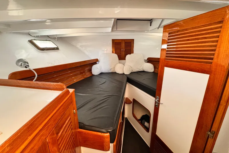 Cozy cabin interior of 1978 Roughwater 41 boat with wooden accents and plush bedding.