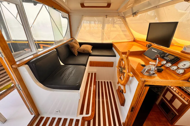 1978 Roughwater 41 boat interior with wooden helm, black seating, and navigation equipment.