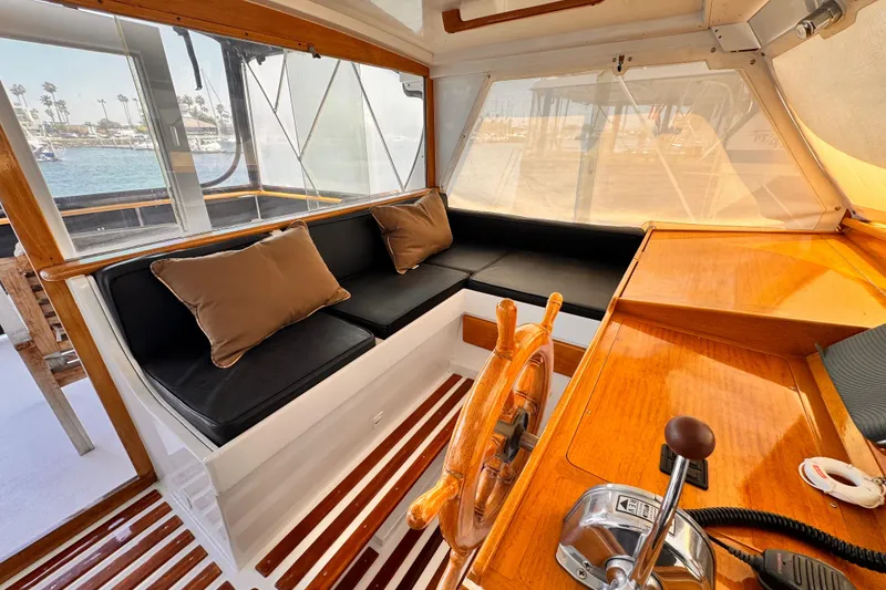 Interior of a 1978 Roughwater 41 boat with wooden helm and cushioned seating.