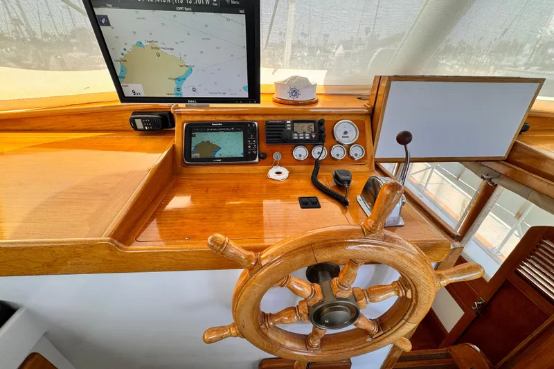 1978 Roughwater 41 boat helm with wooden wheel, navigation screens, and control instruments.