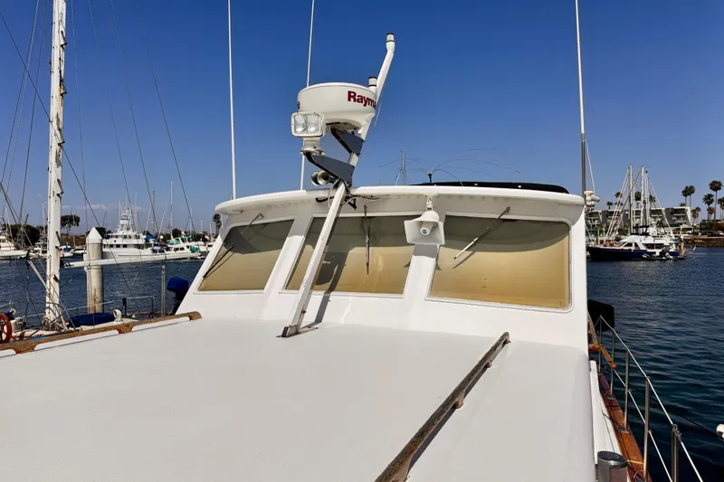 1978 Roughwater 41 boat docked in a marina under clear blue skies.