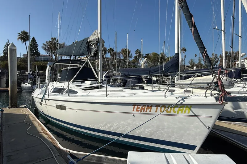 1999 Hunter Passage 420 sailboat named "Team Toucan" docked at a marina.