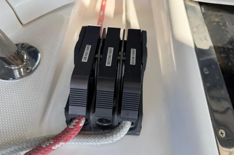 Rope clutches on 1999 Hunter Passage 420 sailboat deck, labeled for jib halyard, second reef, boom vang.