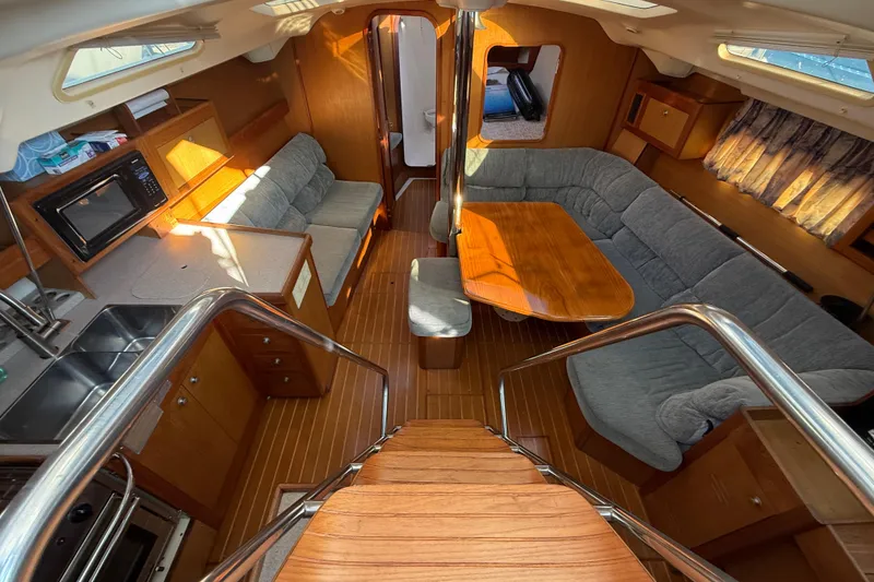 Interior of 1999 Hunter Passage 420 yacht with cozy seating and wooden finishes.