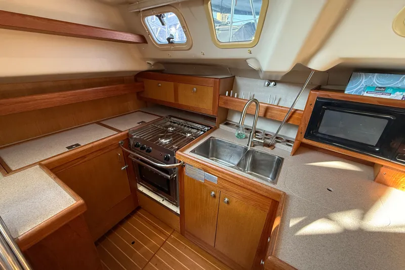1999 Hunter Passage 420 yacht kitchen with stove, sink, and microwave.