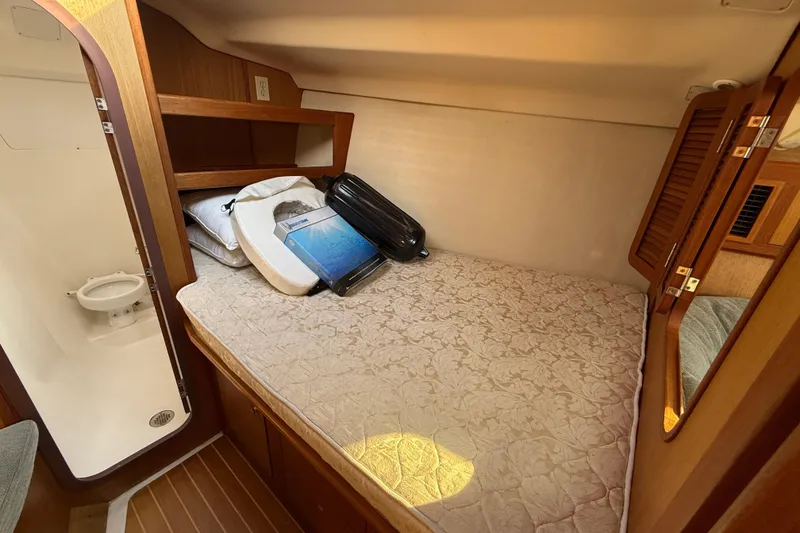 1999 Hunter Passage 420 cabin interior with bed, storage, and adjacent bathroom.
