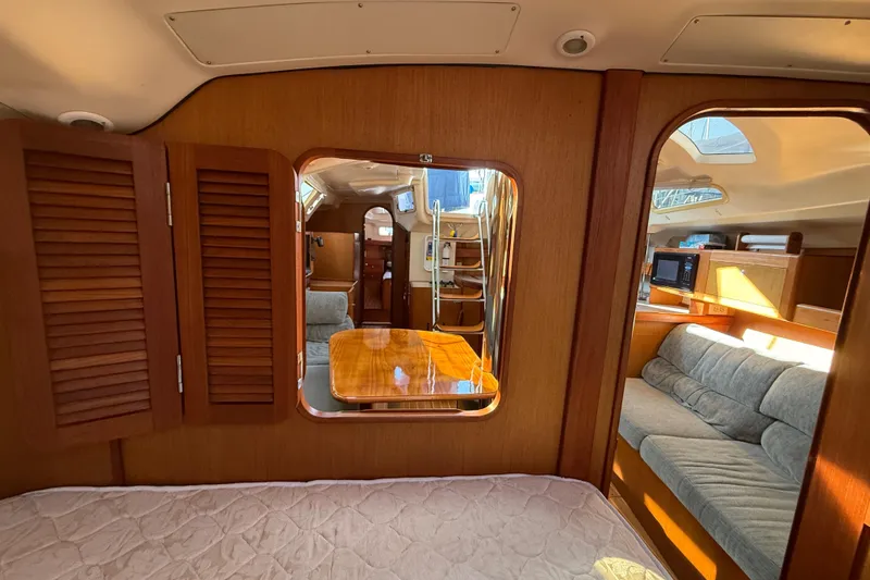 Interior of 1999 Hunter Passage 420 yacht with cozy seating and wooden finishes.