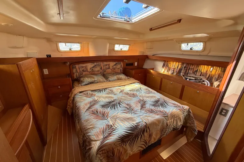 1999 Hunter Passage 420 yacht interior with cozy bedroom and wooden cabinetry.