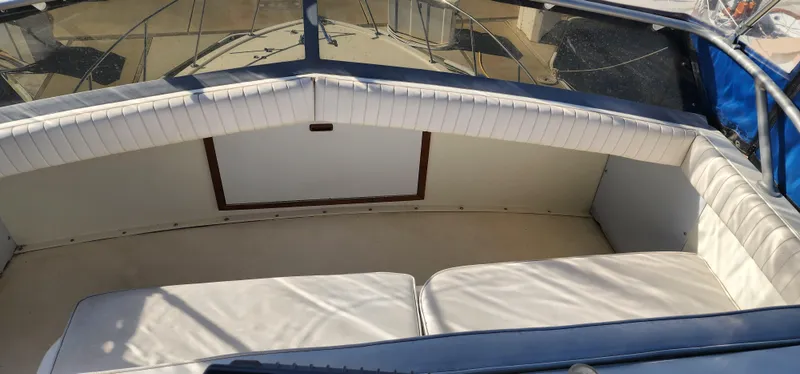 1985 Bertram 33 Flybridge Cruiser interior with cushioned seating and windshield.