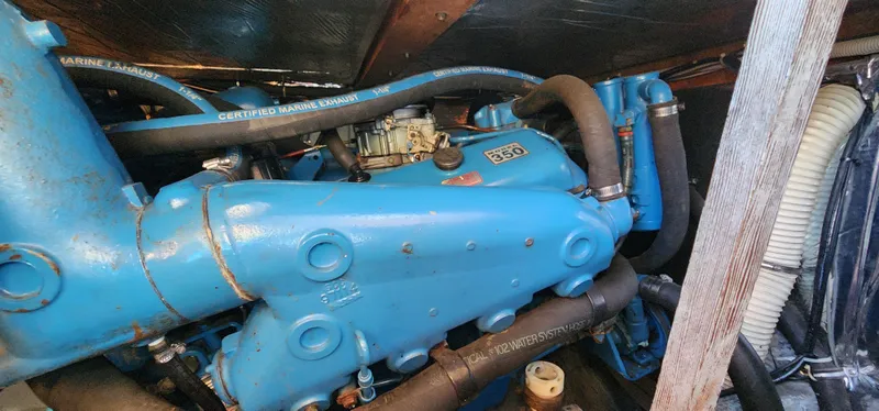 Engine compartment of a 1985 Bertram 33 Flybridge Cruiser with blue components and hoses.