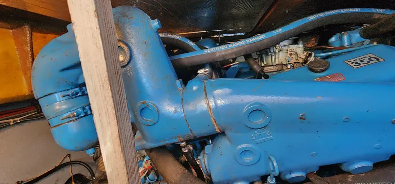 Engine compartment of a 1985 Bertram 33 Flybridge Cruiser, featuring a blue marine engine.