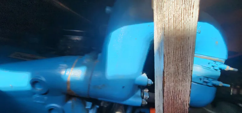 Engine compartment of a 1985 Bertram 33 Flybridge Cruiser, featuring a blue engine component.