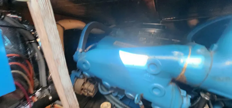 Engine compartment of a 1985 Bertram 33 Flybridge Cruiser with visible blue machinery.