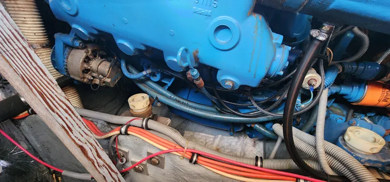 Engine compartment of a 1985 Bertram 33 Flybridge Cruiser with visible wiring and components.