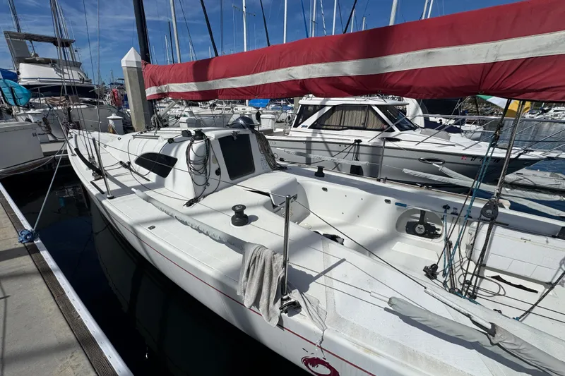 Sailboat docked at marina, Flying Tiger 10M, 2007 model, with red sail cover.