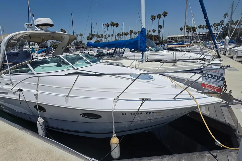 2001 Doral 250se boat docked at marina, for sale sign visible.