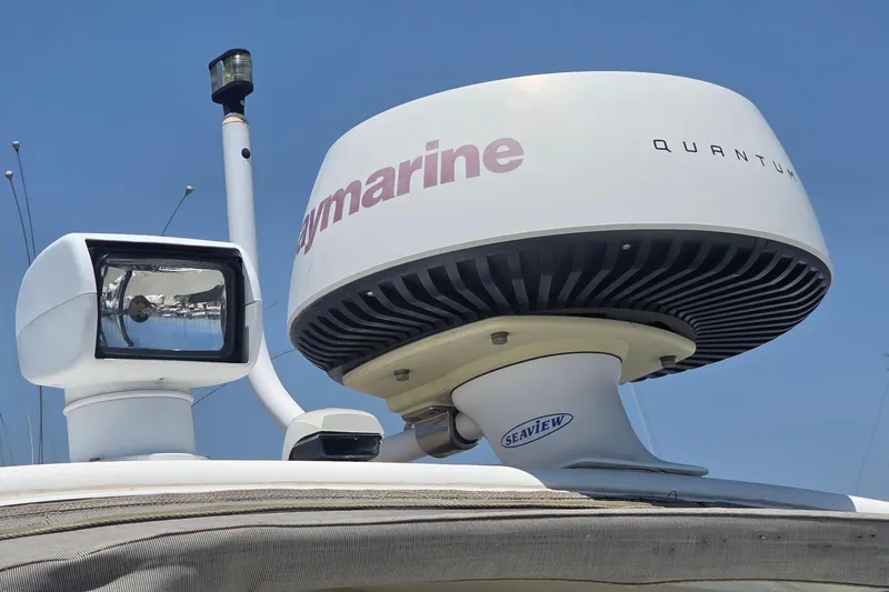 Radar and spotlight on a 2001 Doral 250se boat under clear blue sky.