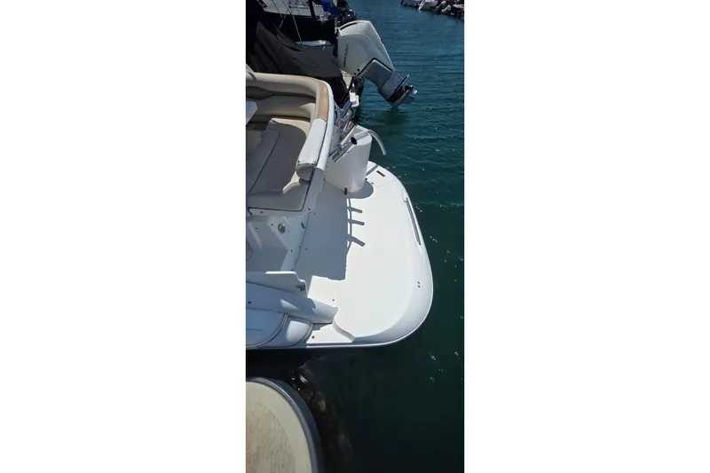 2001 Doral 250se boat stern view with seating and outboard motor in marina.