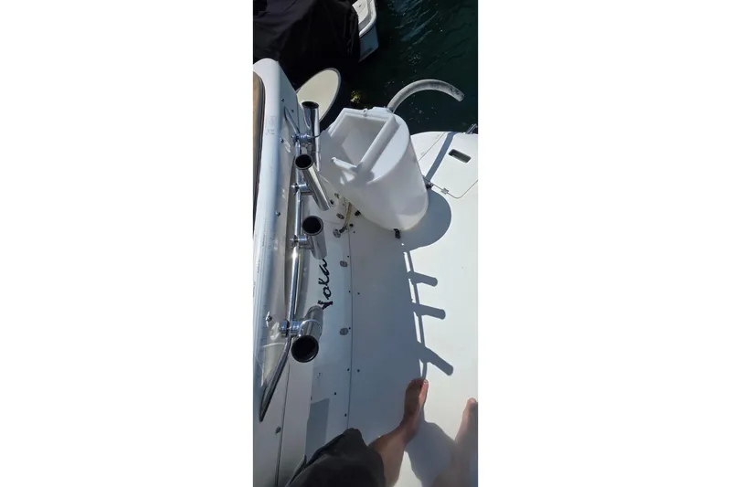 2001 Doral 250se boat deck with rod holders and a white seat.