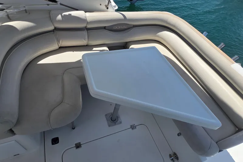 Luxurious seating area on a 2001 Doral 250se boat with a white table.