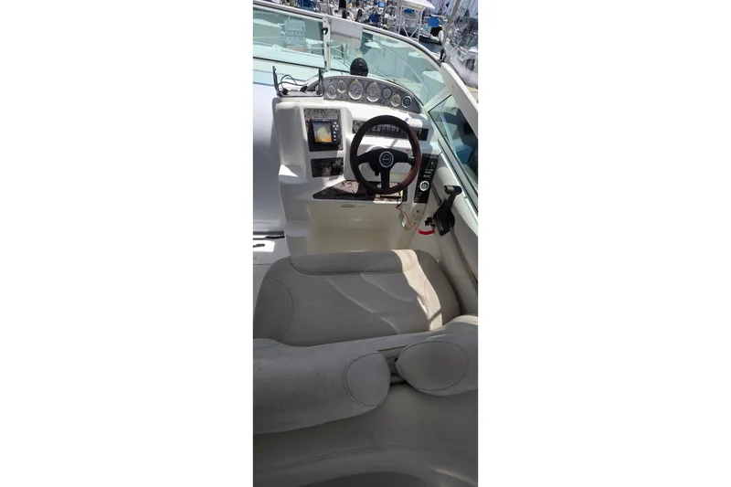 Interior view of a 2001 Doral 250se boat cockpit with steering wheel and controls.