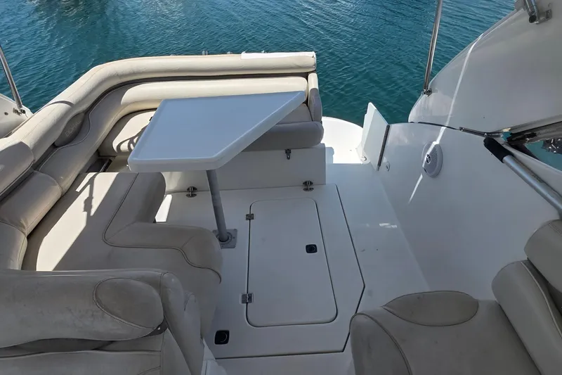 Interior of a 2001 Doral 250se boat with seating and table on calm water.