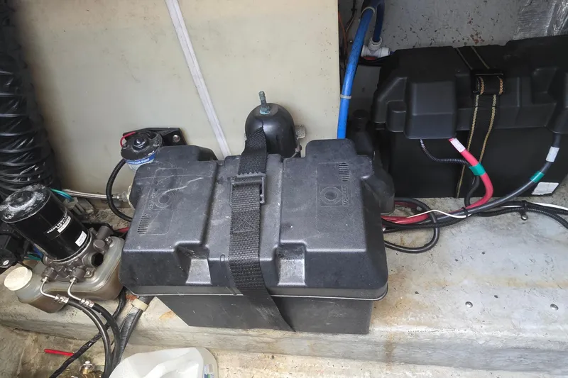 Battery compartment of a 2001 Doral 250se boat with wiring and components.