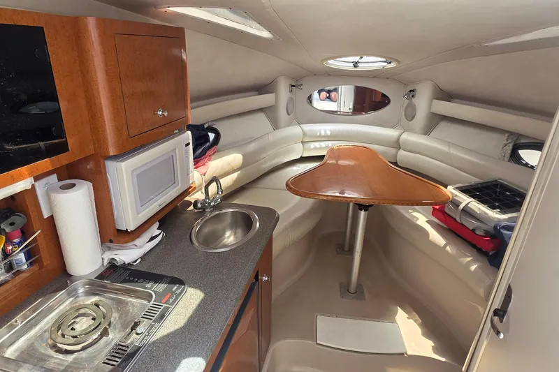 Interior of a 2001 Doral 250se boat with kitchenette and seating area.