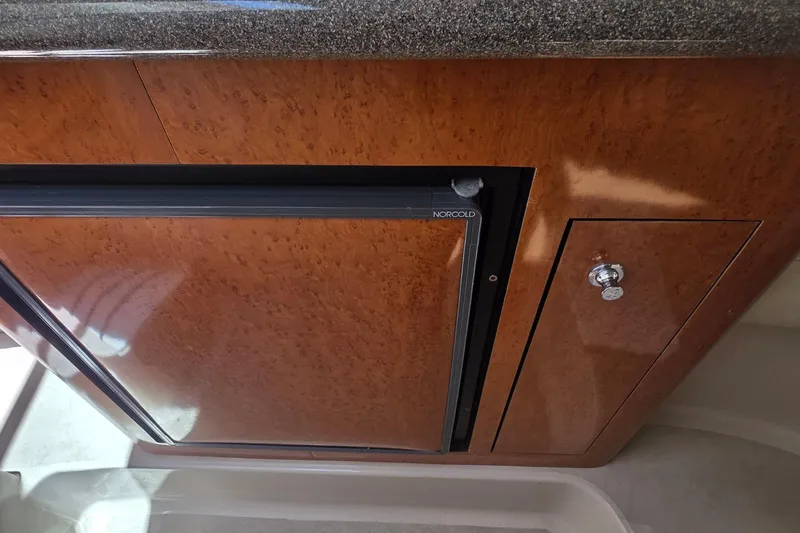 Wooden cabinet with Norcold fridge in 2001 Doral 250se boat interior.