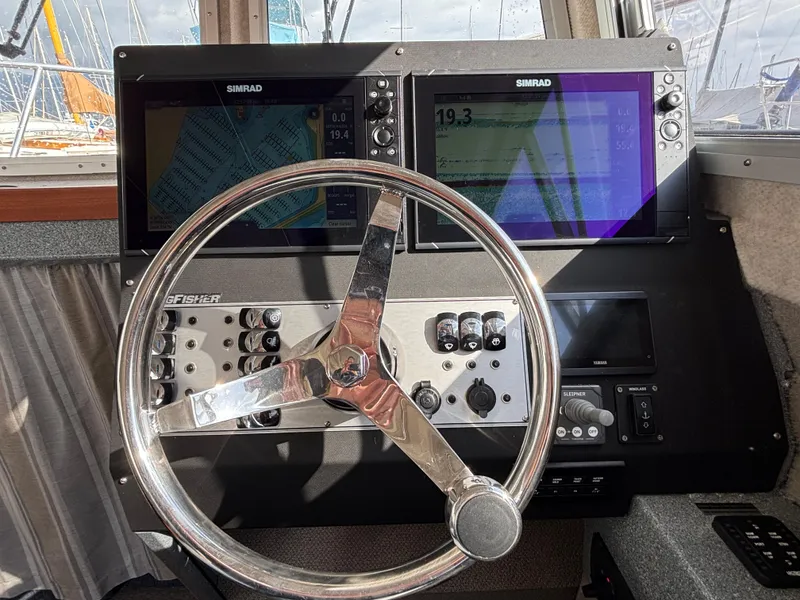 2023 KingFisher 3025 Destination boat dashboard with dual Simrad displays and steering wheel.