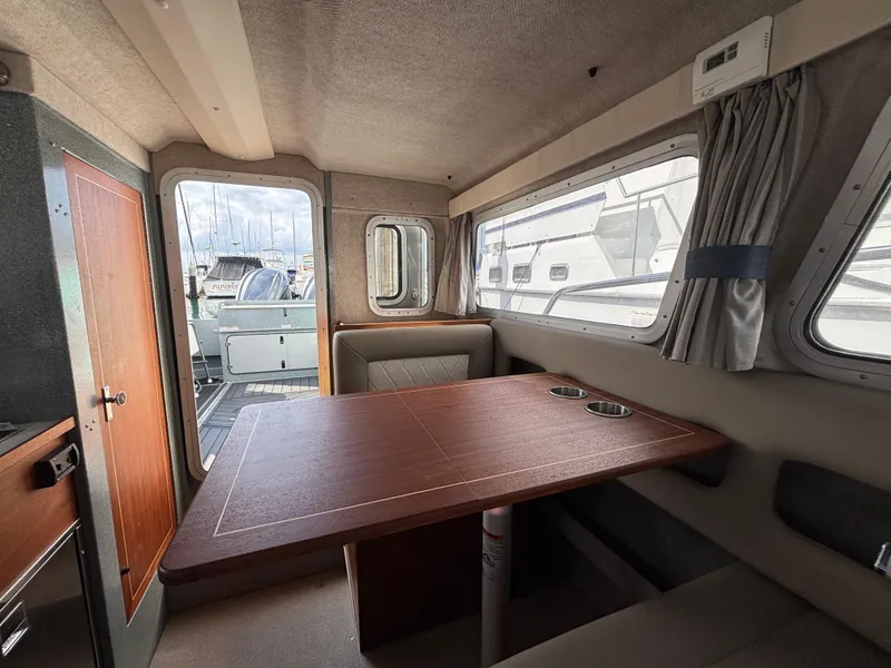 Interior of 2023 KingFisher 3025 Destination boat with wooden table and seating.