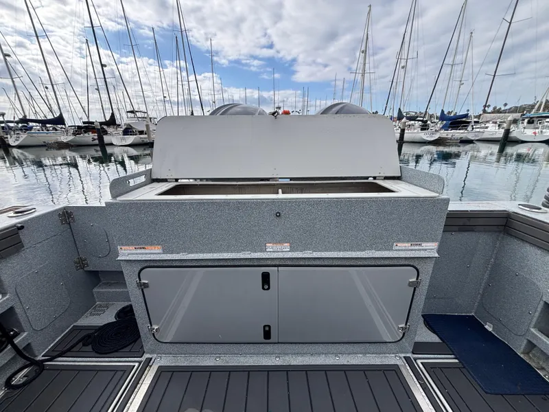 2023 KingFisher 3025 Destination boat interior with storage, docked at marina with sailboats.