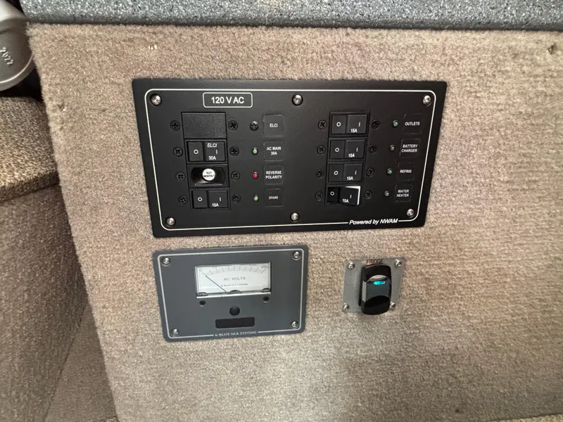 Electrical panel on 2023 KingFisher 3025 Destination boat, featuring 120V AC controls and switches.