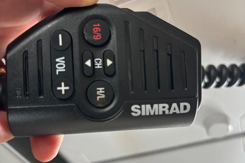Hand holding Simrad marine radio microphone on KingFisher 3025 Destination, 2023 model.