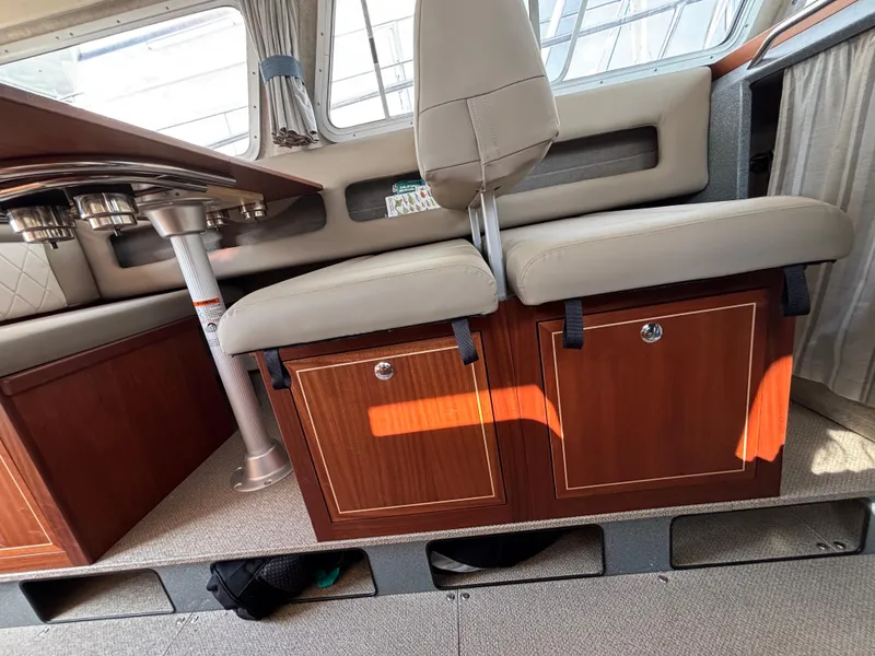Interior of 2023 KingFisher 3025 Destination boat with seating and wooden storage cabinets.