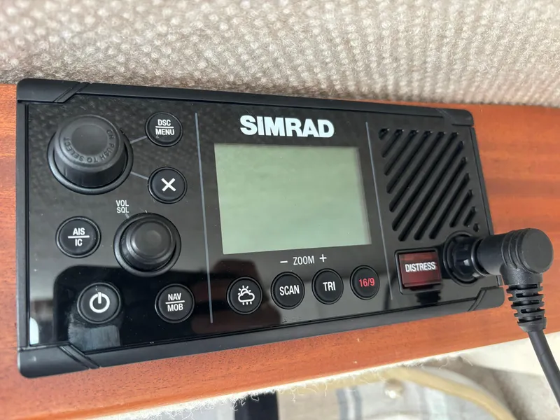Simrad marine radio on 2023 KingFisher 3025 Destination boat, featuring distress button and control knobs.