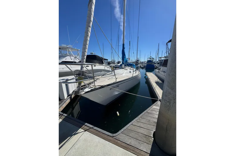1985 Catalina 38 sailboat docked in a marina under clear blue skies.